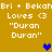 Two identical pixelated text on a mustard background, each displaying 'Bri + Bekah Loves <3 "Duran Duran"' with a heart symbol between them