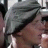 Pixelated close-up of a person's face with dark hair and a light-colored garment, set against a blurred background.