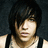 Pixelated close-up of a person with dark hair and light skin wearing a sleeveless top against a dark background.