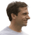 Pixelated profile view of a person with short dark hair wearing a light-colored shirt against a white background.