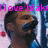 Pixelated image of a person with dark hair and beard, wearing blue clothing, against pink and blue background with partial text.