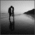 Black-and-white pixelated image of a figure standing on water with a distant landmass, rendered in low-resolution grayscale.