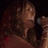 A woman in a red dress holds a microphone, her head turned left, then right, with a striped headband visible in the second view.