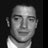 Static grayscale buddy icon of a person's face with visible pixelation and dithering effects on a dark background.