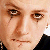 A pixelated close-up of a person's face showing eyes, nose, and mouth with a neutral expression, wearing dark clothing.