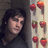 A static image shows a person with dark hair leaning against a wall, next to six strawberries arranged in two on a light surface
