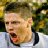 Static 48x48 pixel icon showing a close-up of a person's face with open mouth, dark hair, and light skin against blurred green/yellow background.