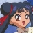 Pixelated anime-style character with dark blue hair tied by red ribbon, light skin, wide eyes, open mouth, blue top, and blurred background.