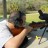 Pixelated image of a person holding a firearm with a blurred background, rendered in low-resolution with visible pixelation.