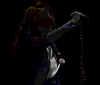 Animated sequence of a person with long hair singing into a microphone, wearing dark jacket and white shirt against black background.