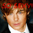Pixelated close-up of a person with light brown hair wearing a white shirt and dark jacket, overlaid with red text reading SO SEXY!