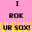 Pink background with black text 'I ROK UR SOX!' repeated twice, yellow pixelated effects below the text.