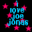 Pixelated blue text reading "i love joe jonas" surrounded by pink stars on a black background, with visible animation changes between frames.