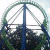 A pixelated static image shows a circular green and blue structure with intersecting lines against a bright background, surrounded by dark foliage.