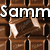 Chocolate bar with white text reading "SammLoves" and partial "Choclo" over brown chocolate squares