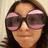 A pixelated image of a person wearing large pink-tinted sunglasses with a brown background and pink text reading "DONT YOU WISH YOUR GLASSES WERE SEXY LIKE MINE".