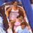 Pixelated image of a person with long brown hair wearing a light pink sleeveless top against a blue background.