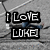 Pixelated image with bold text "I LOVE LIKE" over a gray background showing a person lying on the ground.