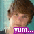 Pixelated image of a person with brown hair against a teal background, featuring a purple text box reading 'yum...' at the bottom.