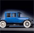 Blue vintage car with large spoked wheels on a dark background, viewed from a low angle.