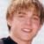 Static 50x50 pixel buddy icon showing a close-up of a person's face with light brown hair and a dark shirt against a blurred background.