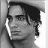 Black-and-white pixelated static icon of a person's face with dark hair, visible facial features including eyes and nose, and partial side profile view against a light background.