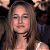 Static 50x50 pixel icon showing a close-up of a person with long brown hair, wearing dark clothing and a choker necklace against a dark background.