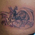Tattooed skin with a dark ink design featuring swirling patterns and abstract shapes, viewed from multiple angles.