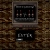Pixelated static image shows a dark rectangular frame with vertical elements resembling book spines on a brown textured background, below which is a smaller black rectangle containing white pixelated text.