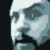 Pixelated grayscale profile of a human face with visible nose, lips, and chin against dark background.