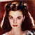 Static pixelated image of a woman with dark hair styled in vintage curls, wearing red lipstick and a light-colored garment against a brown background.