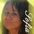 A pixelated close-up of a person with dark hair and light skin, wearing a checkered accessory on the right side.