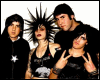 Group of five people in black clothing with spiky hair poses against white background, making peace signs and varied expressions.
