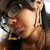 A woman with dark hair and large round glasses wears gold hoop earrings, her head slightly tilted in a close-up view.