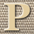 A static 48x48 pixel buddy icon featuring a large beige letter P with black outline on a brown checkered background.