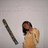 A pixelated figure with dark hair holds a long, striped object against a light gray background.
