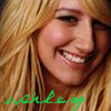 A close-up of a smiling person with long blonde hair, featuring green handwritten text at the bottom left.