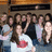 Group of people in a pixelated image with one person wearing white shirt featuring red heart symbol, others in dark and light clothing.