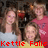 Two people in a group pose with one person in a red shirt and another in a light blue shirt, with red text reading 'Kettle Falls' and 'YUM!!' at the bottom.