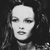 Pixelated grayscale image of a person's face with closed eyes, dark hair, and a neutral expression against a dark background.