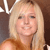 Static pixelated image of a person with long blonde hair wearing a brown sleeveless top against a dark background.