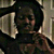 Pixelated static image of a person with dark hair and a light-colored garment, partially obscured by a large, light-toned object on the left side.