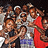 Group of people in a crowded pose with one person holding red fabric, visible text "FRANKSICONS" on the right side.