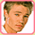 Pixelated static image of a person's face with brown hair and light skin, framed by a pink border on a white background.