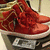 Red sneakers with gold accents on a white sole, displayed in a of four showing slight variations