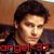 A pixelated image of a person with dark hair and light skin, wearing a dark shirt against a brown background.