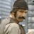 Pixelated image of a person with dark hair and a mustache wearing a light-colored shirt against a blurred background.