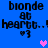 Blue background with repeated pixelated text 'blonde at heart..! :3' and two heart symbols, one pink and one purple, in different positions across frames.