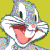 Pixelated cartoon character with wide eyes, pink tongue sticking out, and multicolored head against yellow background.