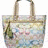 A pixelated tote bag with floral patterns and a green strap, next to an abstract arrangement of pastel-colored circular shapes.